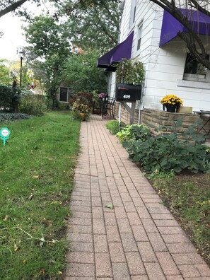 A paved pathway leading to a house with a mailbox marked '409'.