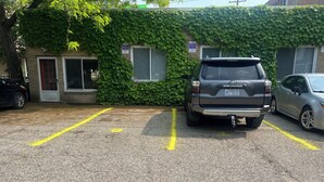 A parking lot with two cars, one SUV and one sedan, parked in designated spaces.