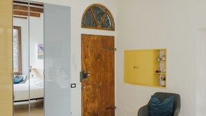 A modern room with a wooden door, a glass partition, a small table, and a chair.
