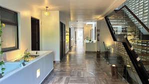 A modern hotel corridor with a wooden floor, a glass railing, and a staircase. - Albra Tulum (Tulum)