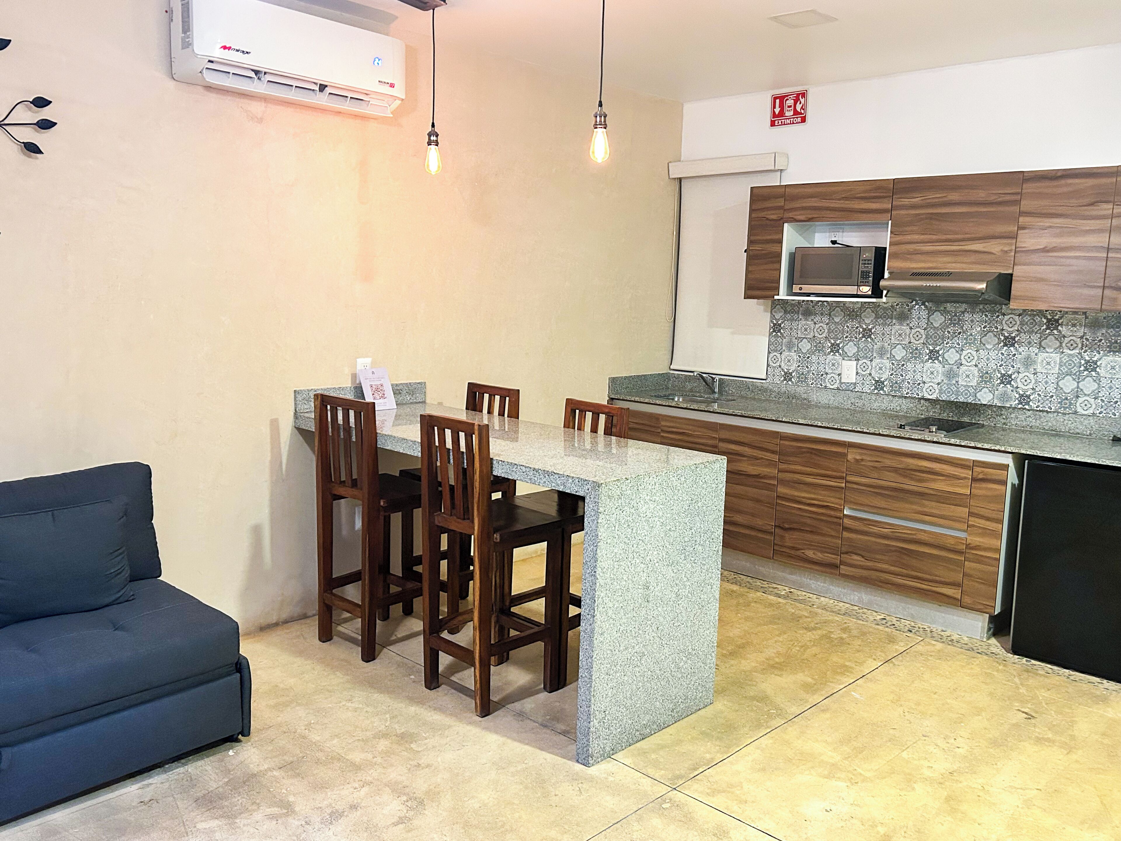 A compact kitchen with a central island, wooden cabinets, and a built-in microwave.