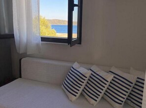 A room with a bed, a window with a view of the sea, and a curtain. - Seaside Retreat Holiday Home with Terrace - Two Bedroom Holiday Home with Terrace (Mali Drvenik)