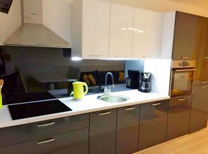 Fully equipped kitchen with a range, sink, and coffee maker.