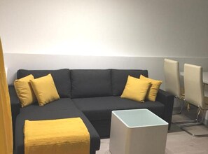 Relax in a stylish living area with a sofa and side table, perfect for unwinding.