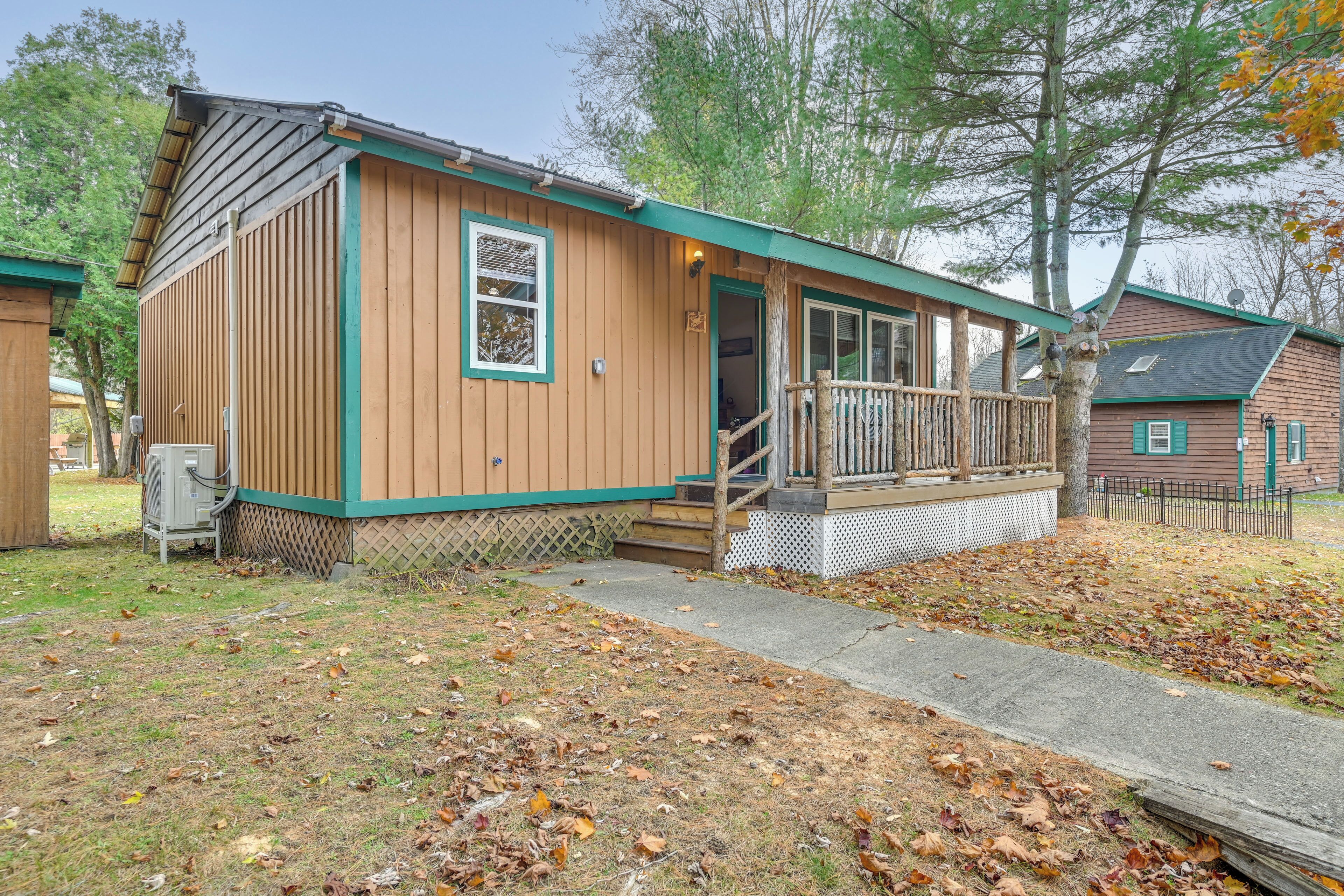 A small wooden cabin with a porch and steps leading to a door.