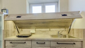 Une cuisine avec un plan de travail en bois, un évier et une fenêtre au-dessus.