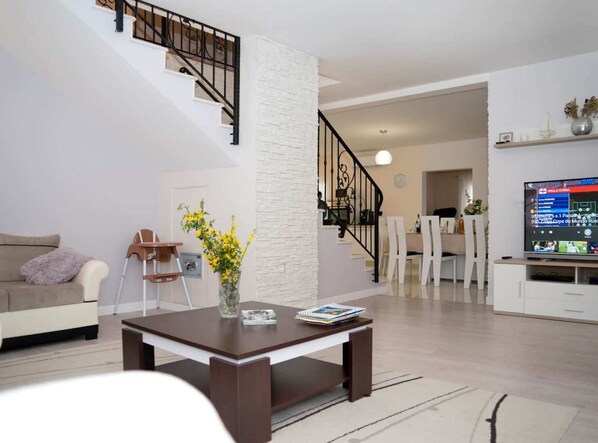 Relax in this stylish living room with a sofa set, coffee table, and dining area.