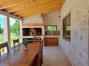 Cozy kitchen and dining area with a fireplace, sink, and dining table.