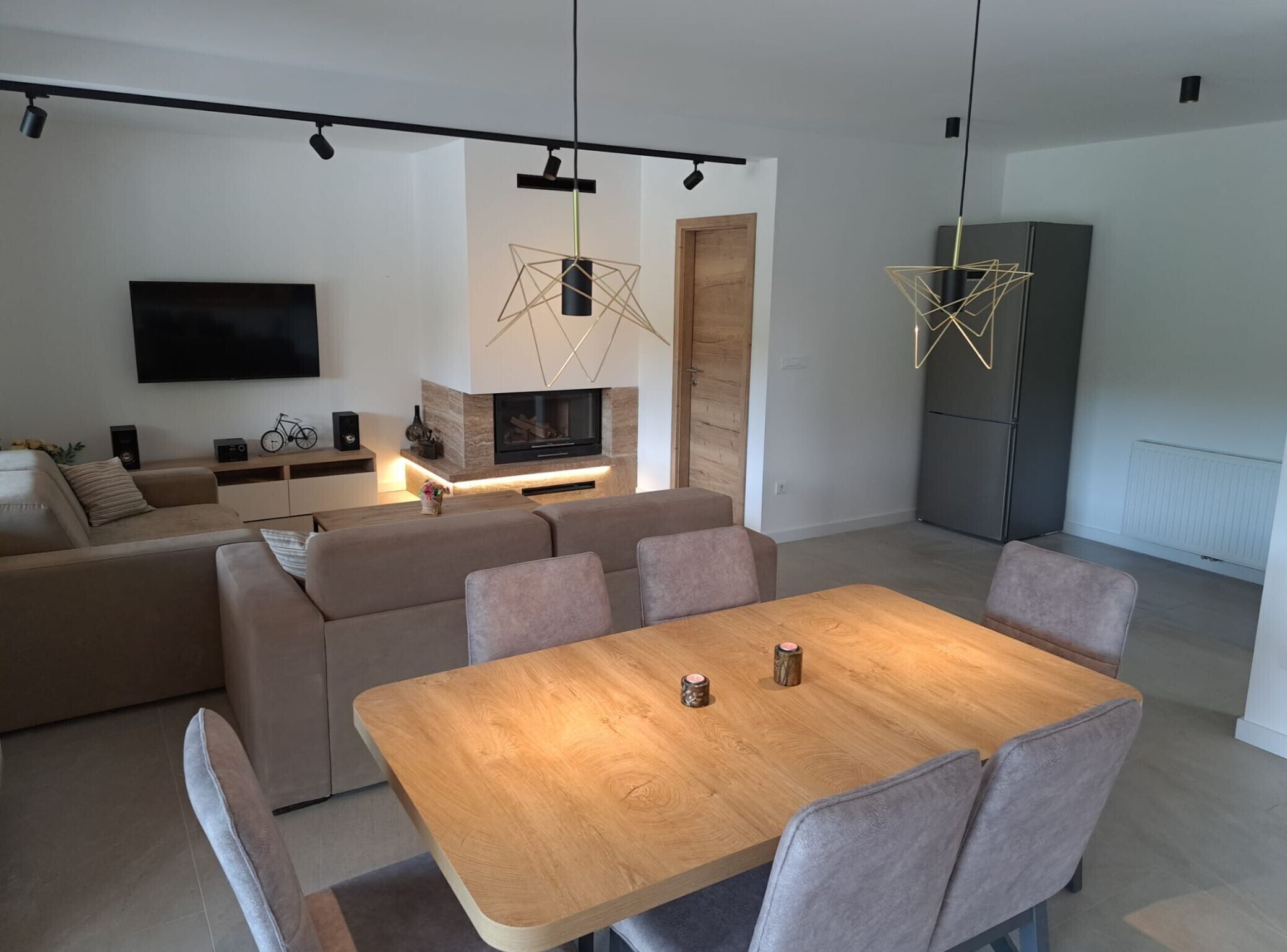 Ein modernes Wohnzimmer mit einer Couch, einem Fernseher und einem Holzessttisch.