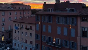 A multi-story building with balconies and a street view at sunset.