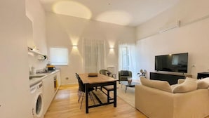 A modern apartment with a kitchen, dining area, and living room.