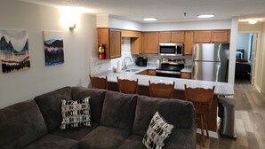 Una cocina moderna con armarios de madera, electrodomésticos de acero inoxidable y encimera de granito.