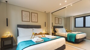 Una moderna camera d'albergo con due letti, un ampio specchio e opere d'arte alle pareti.