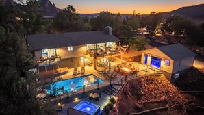 Une maison moderne dotée d’une piscine, d’un jacuzzi et d’un espace salon extérieur.