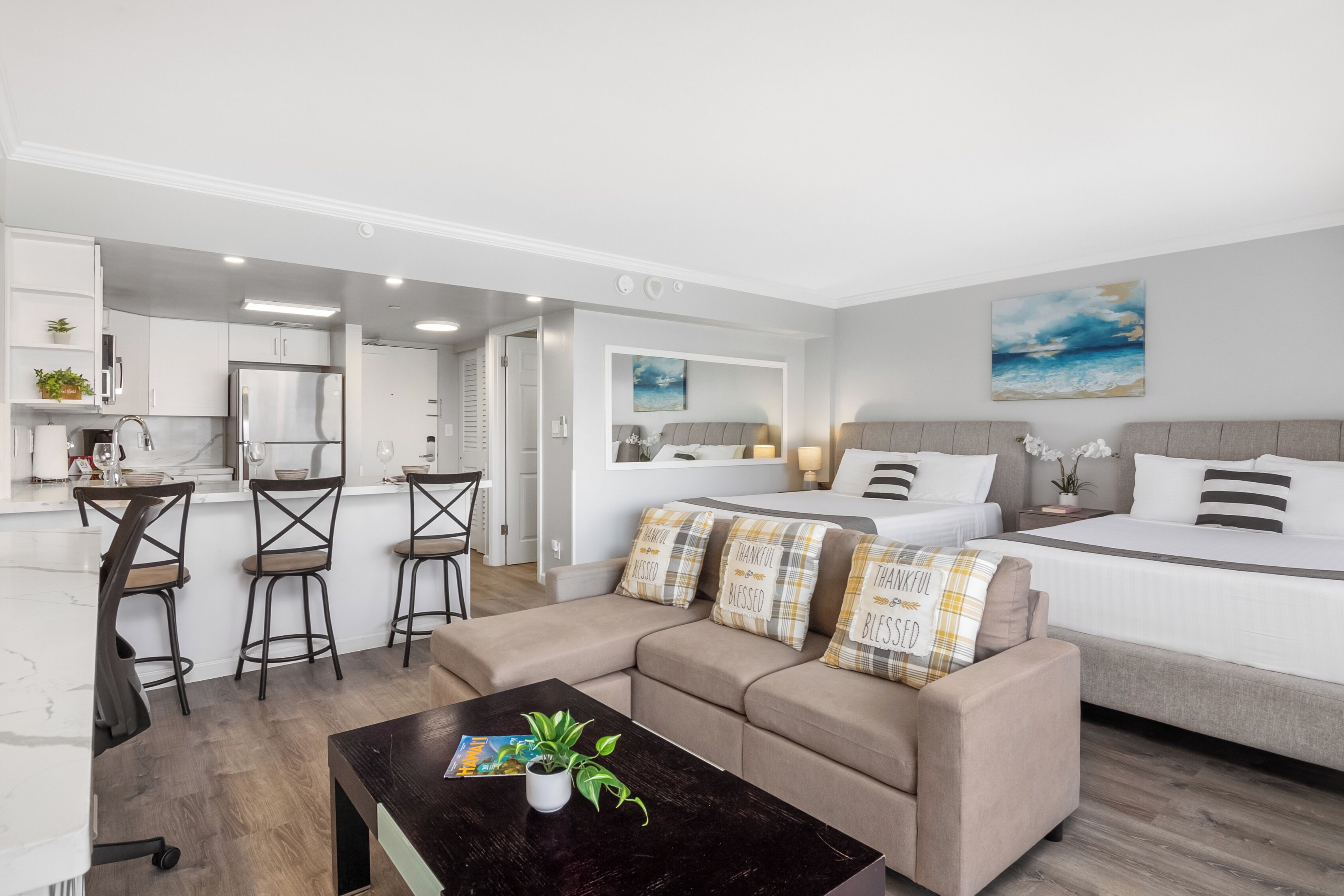 A modern apartment with a kitchen, a dining area, and a living room with a sofa and a coffee table.