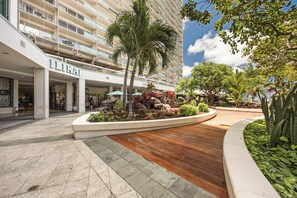 A hotel entrance with a palm tree, a rock garden, and a wooden deck. - Ilikai Hotel Condo at Waikiki No Parking (Honolulu)