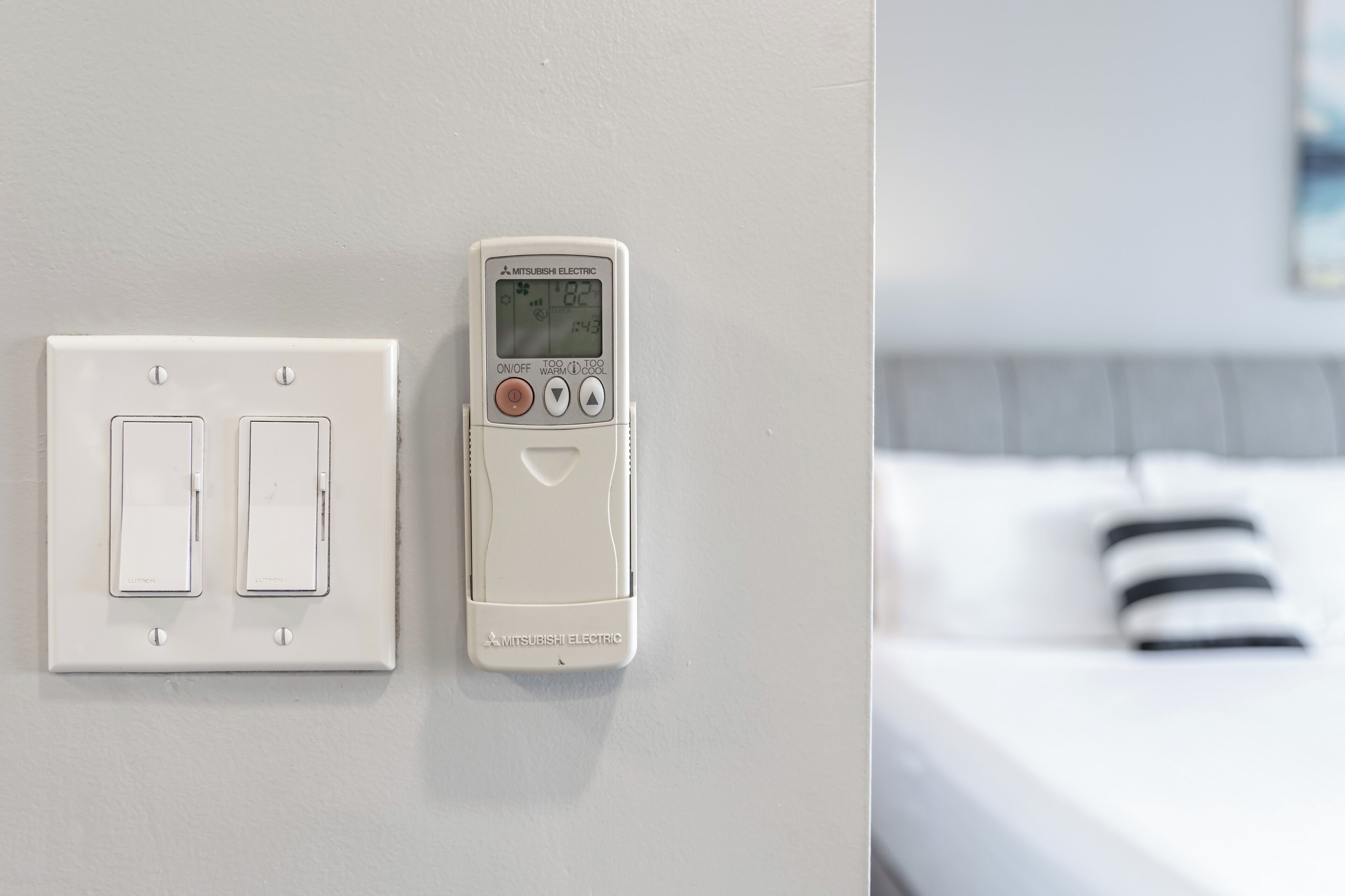 A wall-mounted control panel with a digital display and two switches.