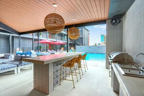 A poolside bar area with seating and a grill. - Chic Condo Minutes to Downtown, Gruene, & More (New Braunfels)