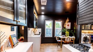 A modern kitchen with a central island, built-in appliances, and a dining area with natural light. - Best Location in Downtown NB | Golf Cart Included! (New Braunfels)