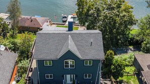 Una casa grande con un césped cuidado y un muelle junto a un lago.
