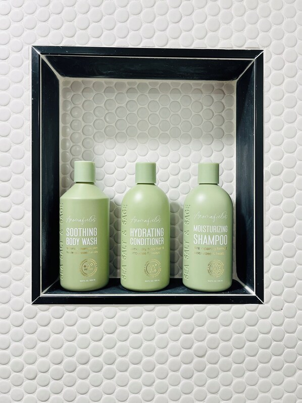A shelf with three bottles of Aromafields body wash and conditioner. - Charming Cozy Unique Tiny Home • Homestead, FL (Homestead)