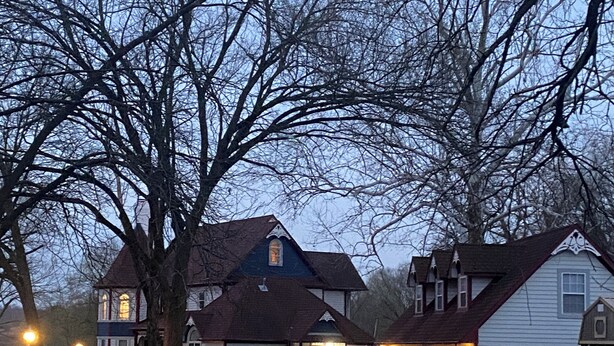 Un quartier résidentiel comprenant plusieurs maisons, dont une maison à deux étages dotée d’un toit à pignon et d’un porche à l’avant.