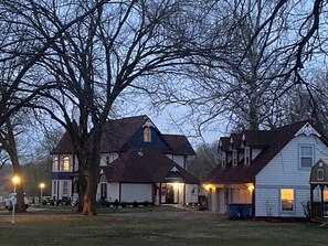 A residential area with multiple houses, including a two-story house with a gabled roof and a front porch.