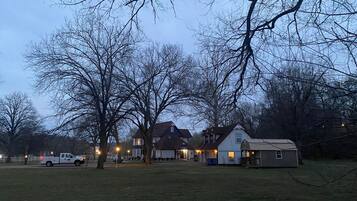 A residential area with houses, a small shed, and a white pickup truck parked on the grass.
