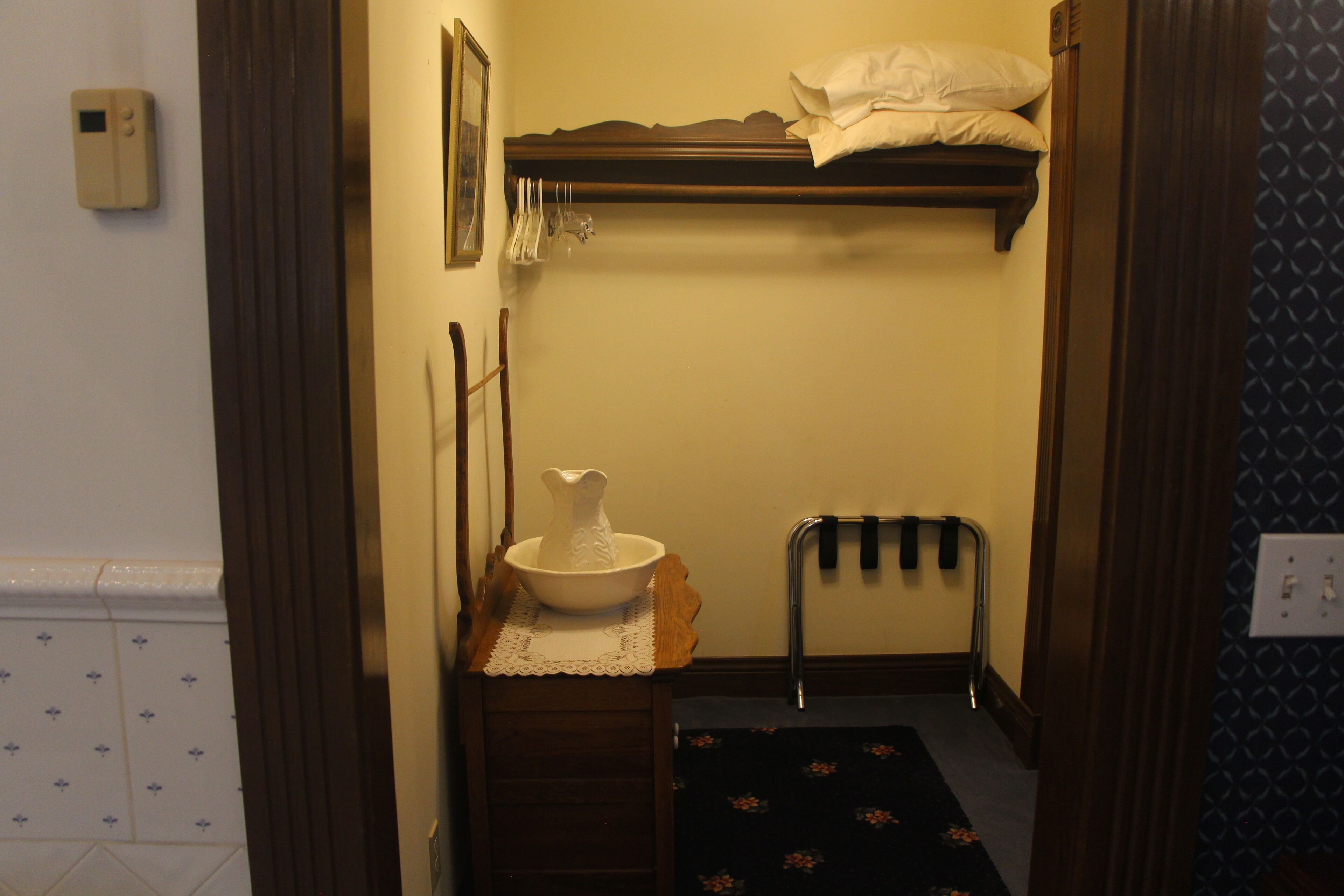 A small bathroom with a sink, a mirror, a towel rack, and a shower area.