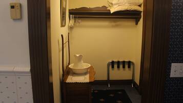 A small bathroom with a sink, a mirror, a towel rack, and a shower area.