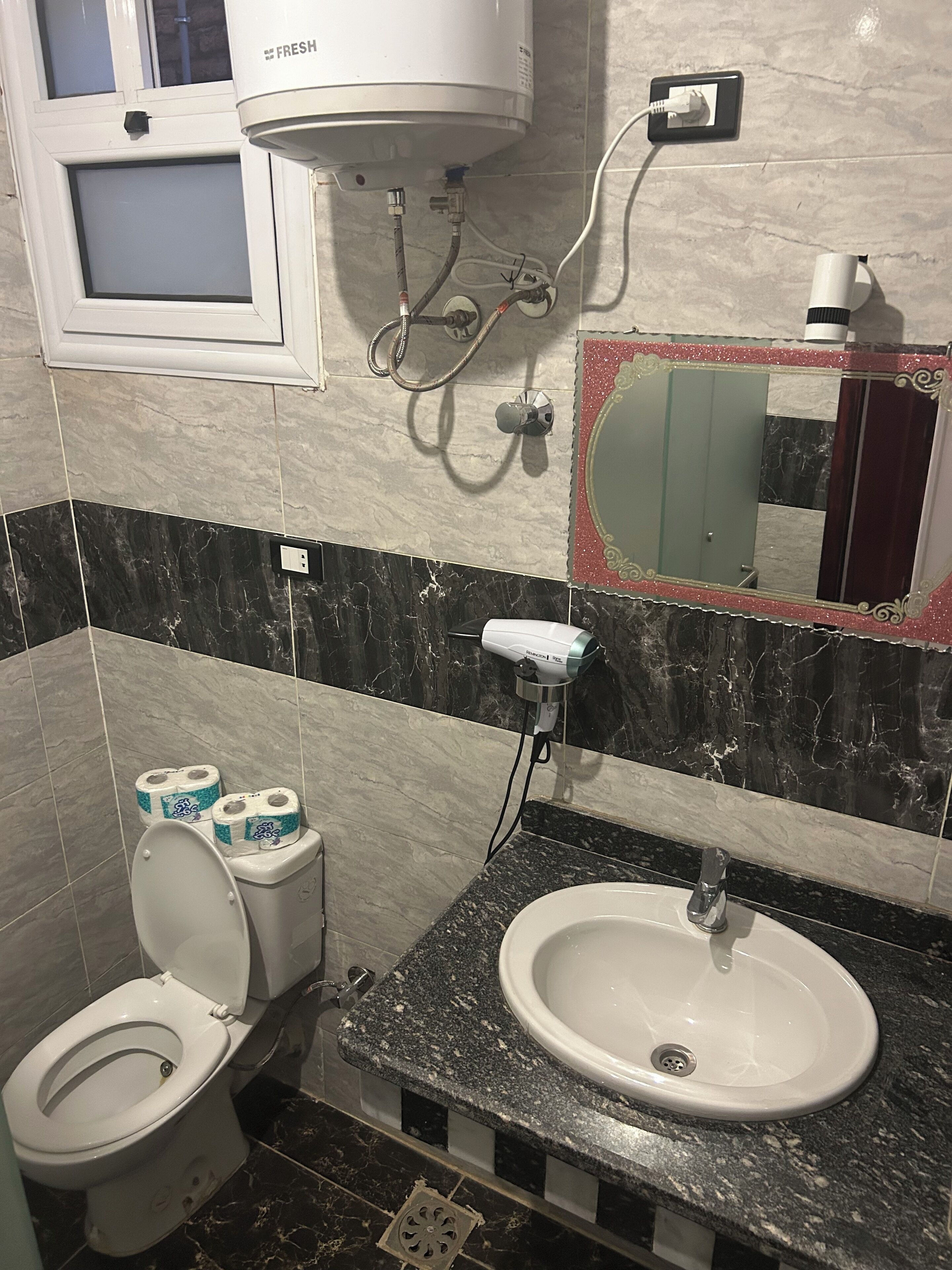 Un baño con inodoro, lavabo y ducha.