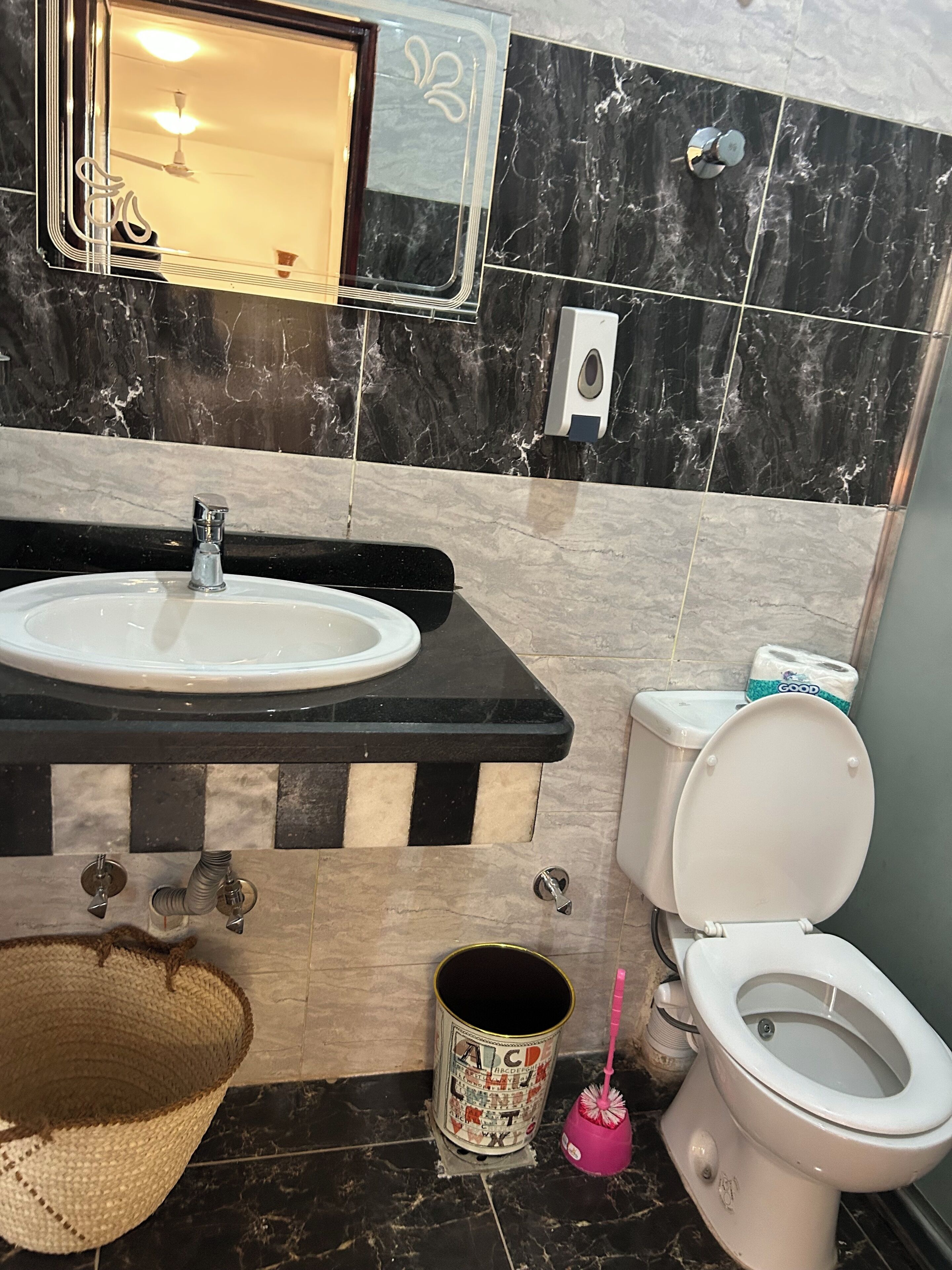 Baño con lavamanos, inodoro y espejo.