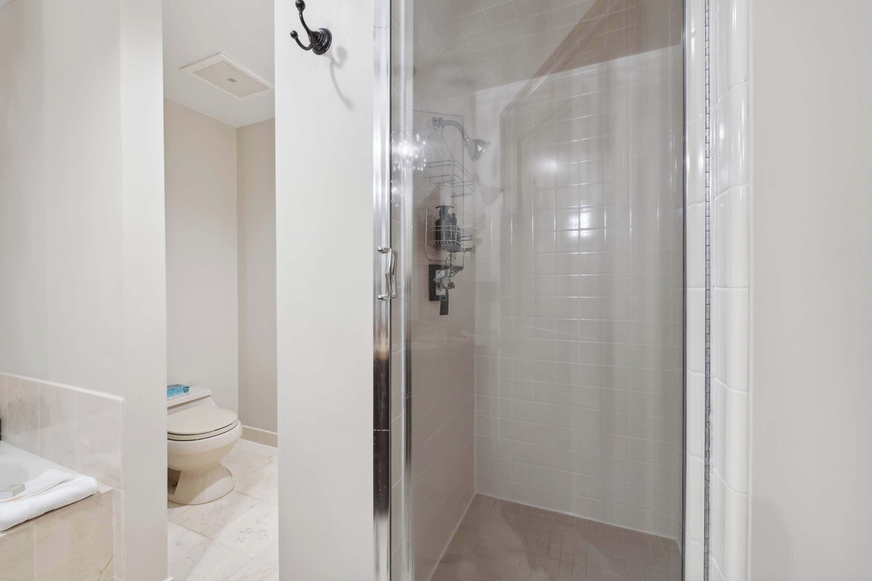 A modern bathroom with a glass-enclosed shower, a toilet, and a bathtub.