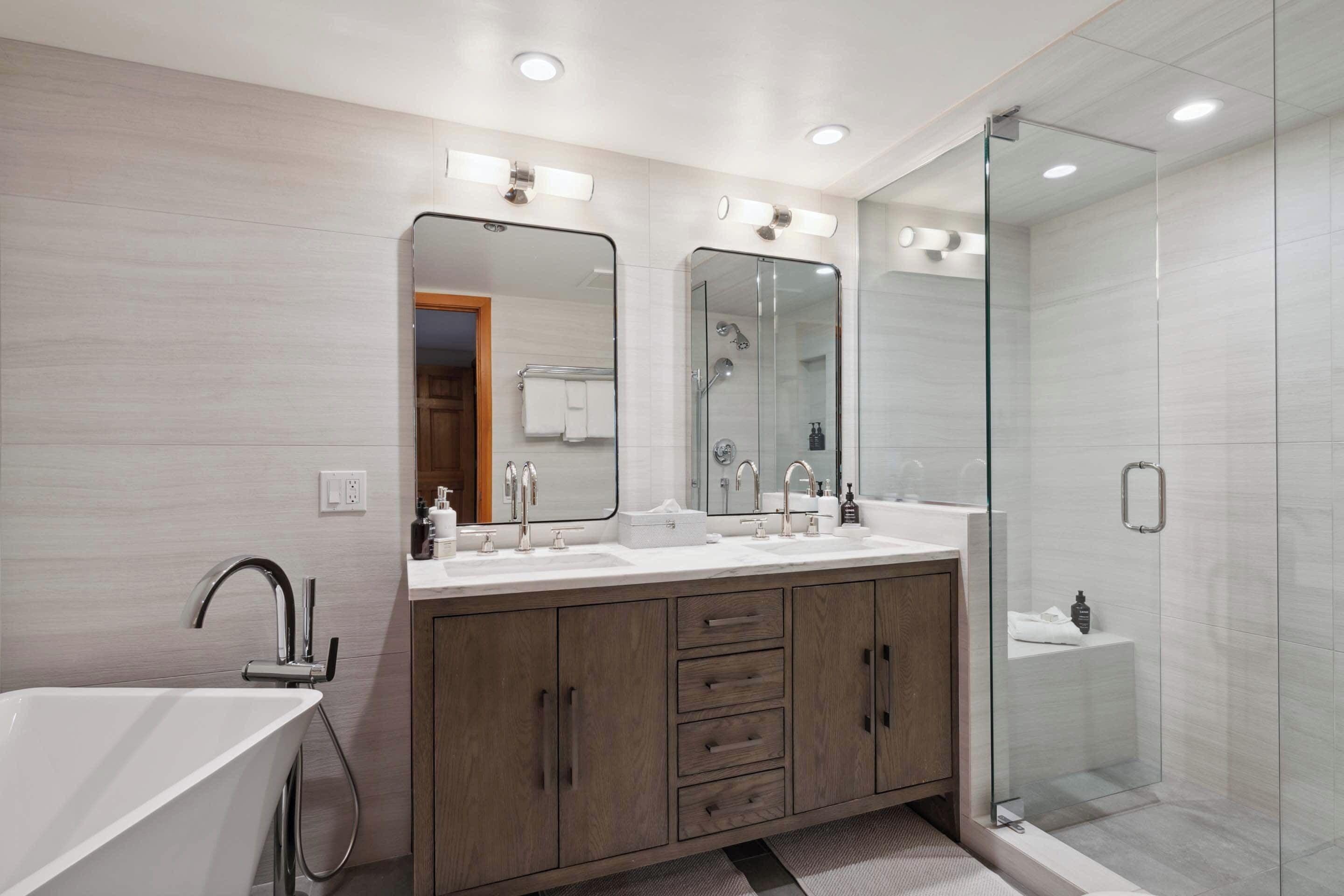 A modern bathroom with a freestanding bathtub, a glass-enclosed shower, and a vanity with a double sink.