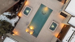 An aerial view of a hotel with a central swimming pool, two smaller pools, and a snow-covered landscape. - Woodrun Place 50 Three Bedroom Residence (Snowmass)