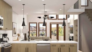 Une cuisine moderne dotée d’un grand îlot central, de meubles en bois et de luminaires suspendus.