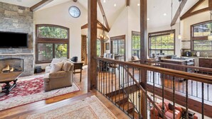 A spacious living area with a fireplace, a large TV, and a cozy seating area. - Woodrun Place 59 Four Bedroom Residence (Snowmass)