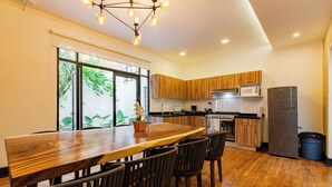 Een moderne keuken met houten kastjes, een centraal eiland en een groot raam.