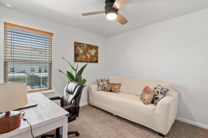 Relax in a stylish living space with a comfortable leather chair, patterned sofa, and lush greenery.