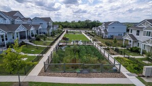 A residential area with houses, a central garden, and a paved walkway. - Relaxing 3BR Retreat Community Pool Gym (Manor)