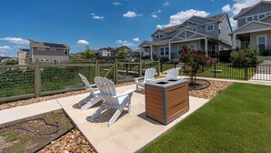A residential area with houses, a fenced garden, and outdoor seating. - Relaxing 3BR Retreat Community Pool Gym (Manor)