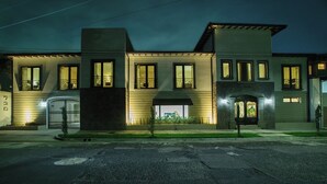 Un edificio de dos pisos con fachada simétrica, ventanas amplias y una entrada central con un pequeño porche.