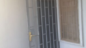A door with a metal grid pattern and a golden handle. - Clinclia Hotels (Ibadan)