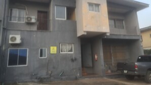 A multi-story building with a flat roof, several windows, and an air conditioning unit. - Clinclia Hotels (Ibadan)