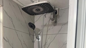 A shower with a handheld showerhead and a wall-mounted control panel. - Beautiful Cozy Private Studio with WiFi in Charming Salisbury (Salisbury)