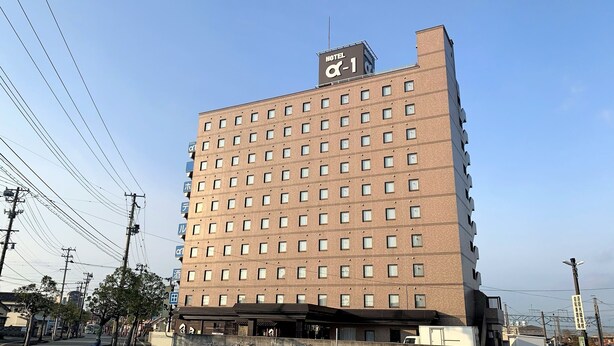 Ein mehrstöckiges Hotel mit einem gut sichtbaren Schild mit der Aufschrift 'HOTEL α-1'.