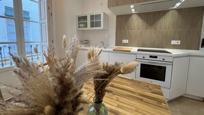 A modern kitchen with white cabinetry, a wooden countertop, and a large window. - Zarzuela (Málaga)
