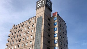 Um edifício de hotel com vários andares e uma placa bem visível que indica ser um hotel.