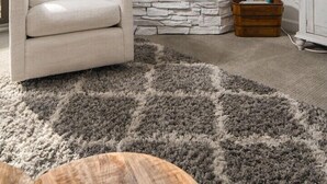Una sala de estar con chimenea de piedra, un sillón cómodo y un tapete decorativo.