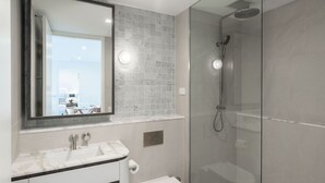 A modern bathroom with a glass-enclosed shower, a marble sink, and a large mirror. - Marina Getaway ~ Captivating 2-bedroom that accommodates up to 4 guests (Shell Cove)